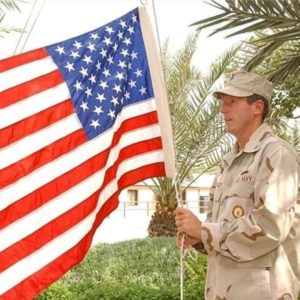Image: Dan Shockley in uniform with American flag